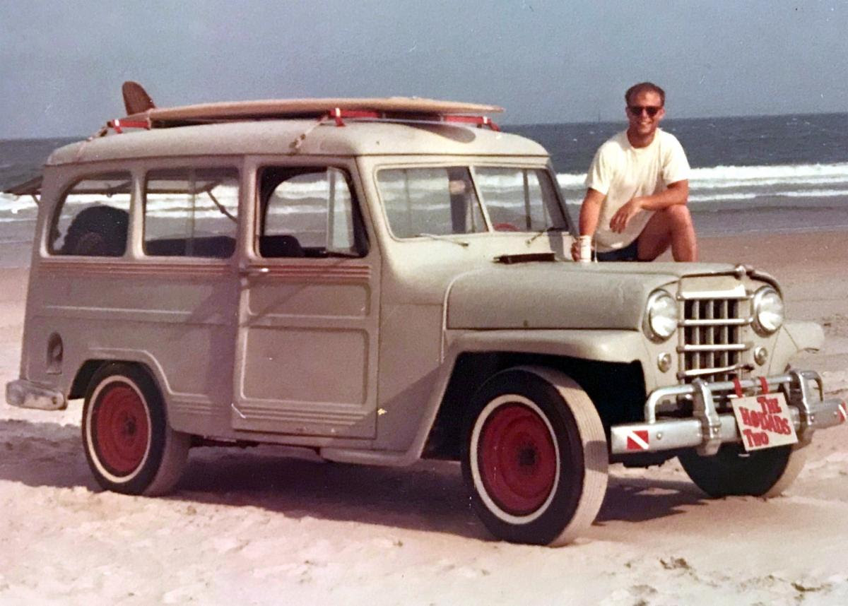 willy outlander jeep with surfer in front of it