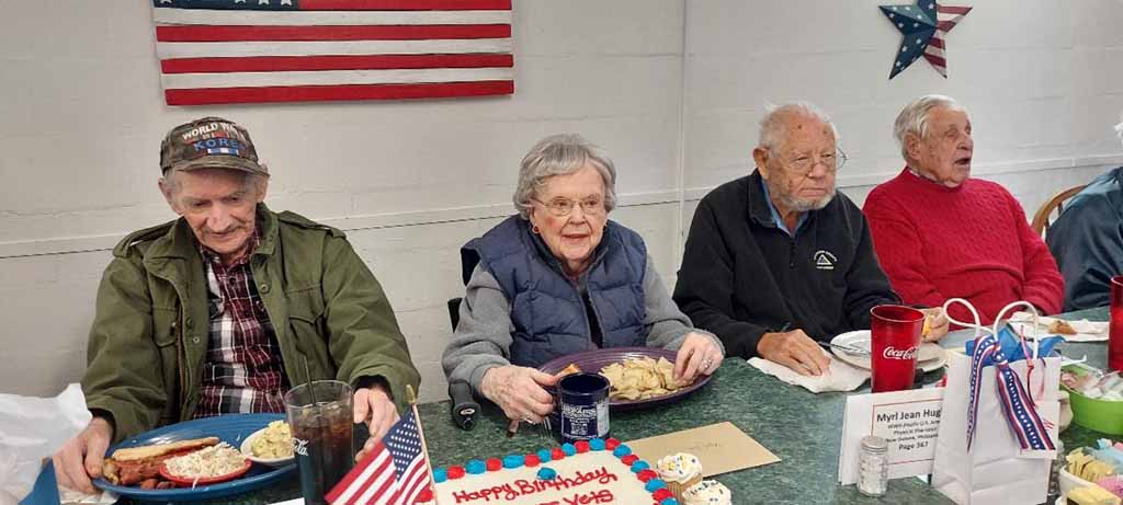 six wwii veterans sitting at table in the musuem